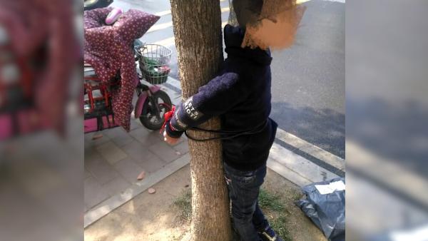 9岁儿子不上学母亲将其绑校门前树上