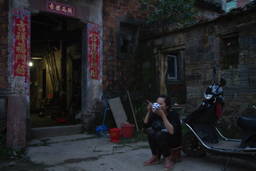 2015年6月，江西省凰岗镇，阿白独自在嫂子家门口吃晚饭。图/丛妍