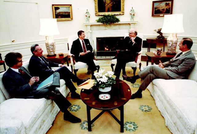 与唐纳德·里甘(左二)和詹姆斯·贝克(右)一起，在椭圆形办公室与里根总统会面。</p><p>（白宫官方照片；保罗·沃尔克的私人收藏）