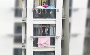 下雨了，楼下被子还晒在外面：楼上住户在自家阳台撑起三把伞