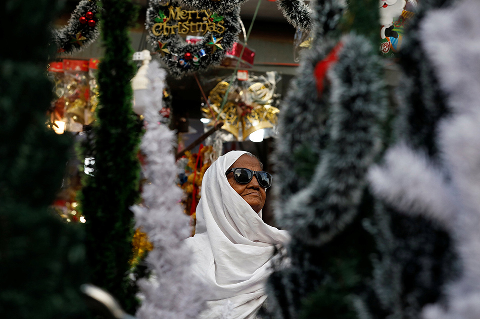 11VCG111180427643A woman looks at Christmas decorations at a stall in Karachi, Pakistan December 6, 2018.