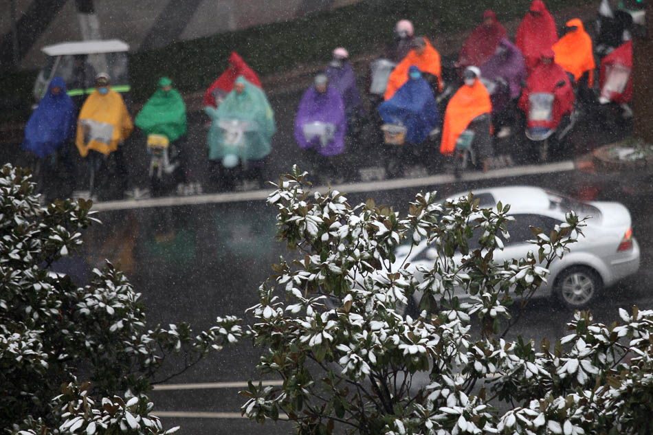 07-1月9日，市民在江苏扬州市街头冒雪骑车出行。当日，我国多地迎来降雪天气。 新华社