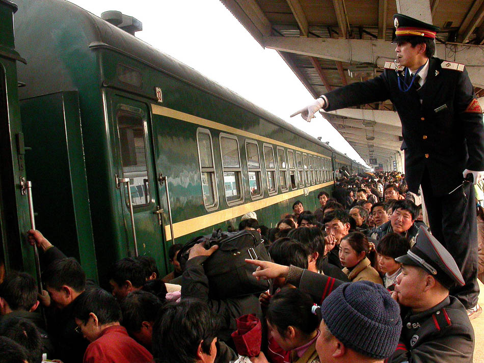 05-VCG114626765742005年1月24日，南京火车站工作人员指挥现场帮助旅客上车。副本