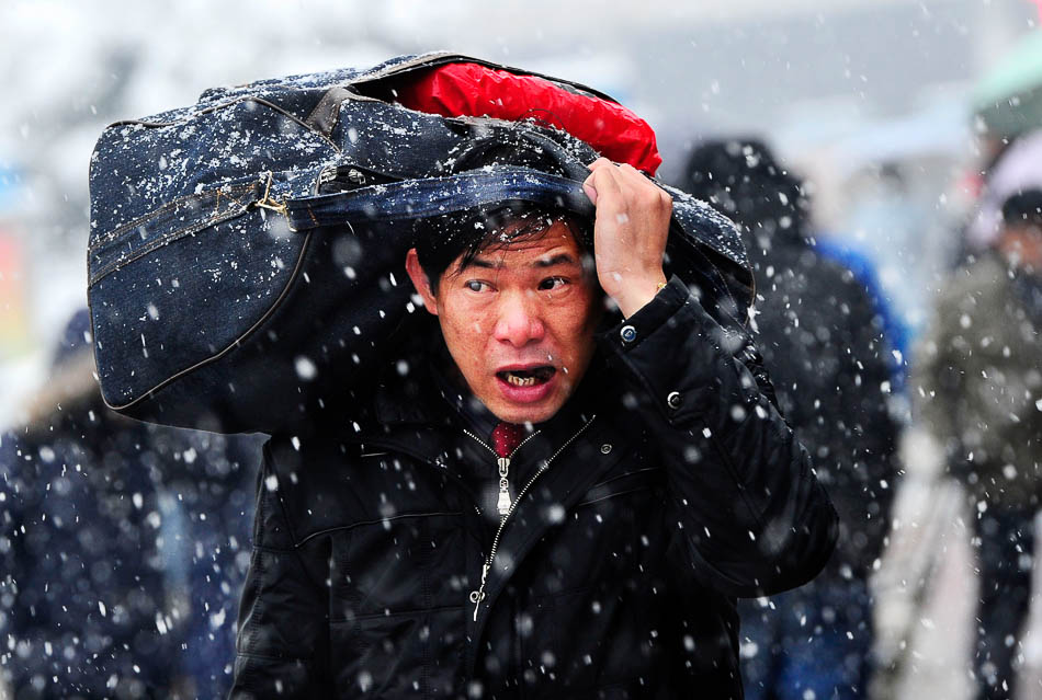 11-VCG114356845262011年1月19日，湖南省长沙火车站广场，一位旅客冒着风雪准备进站。当天，为期40天的2011年春运大幕正式拉开。受强冷空气南下影响，长沙遭遇罕见暴雪天气，市区大雪围城。该市启副本