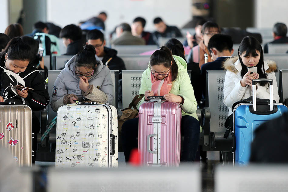 22-VCG114981816772017年1月13日，安徽淮北火车站，乘客在侯车时玩手机。副本