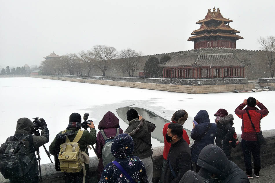 03-VCG1111915924422019年2月14日，北京再次喜降春雪，市民扎堆故宫角楼忙拍照。