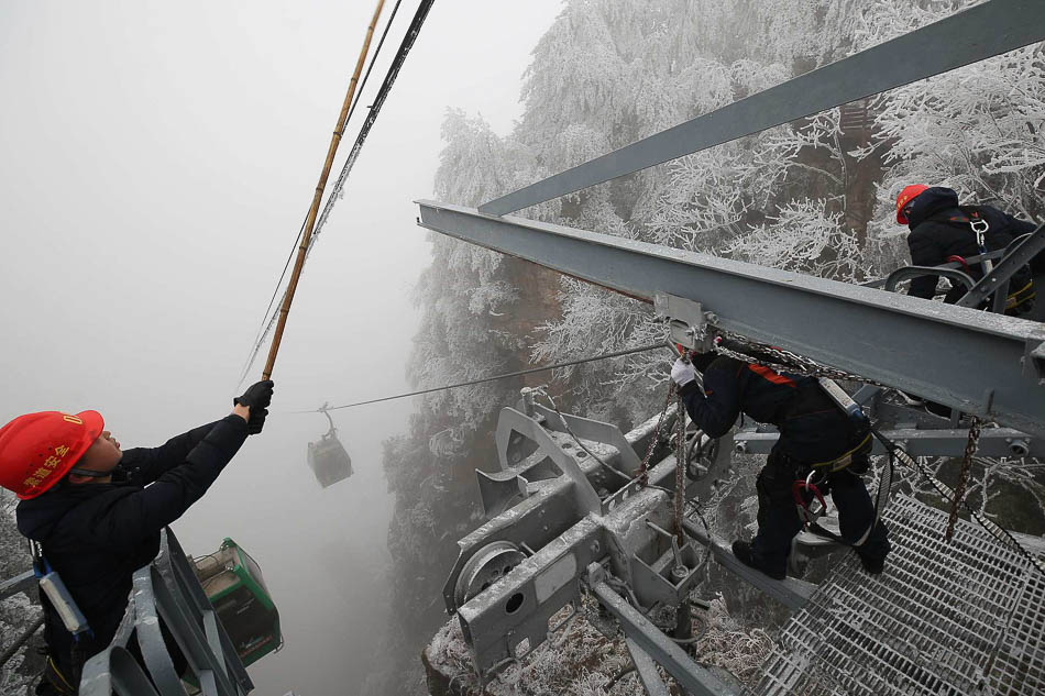 08-VCG1111915802262019年2月14日，湖南张家界武陵源黄石寨索道工作人员在索道支架上清除积冰。