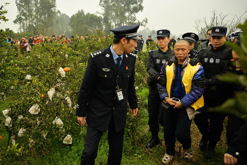 08-6043550230946777192019年2月23日，四川眉山，民警押解冯学华前往犯罪现场指认，远处有许多村民围观。