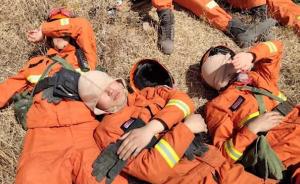 连续奋战12个小时后，森林消防战士在火场边席地而睡
