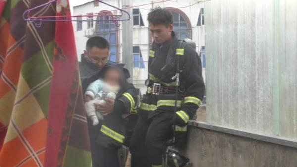 店铺着火，消防员脱下战斗服抱出婴儿