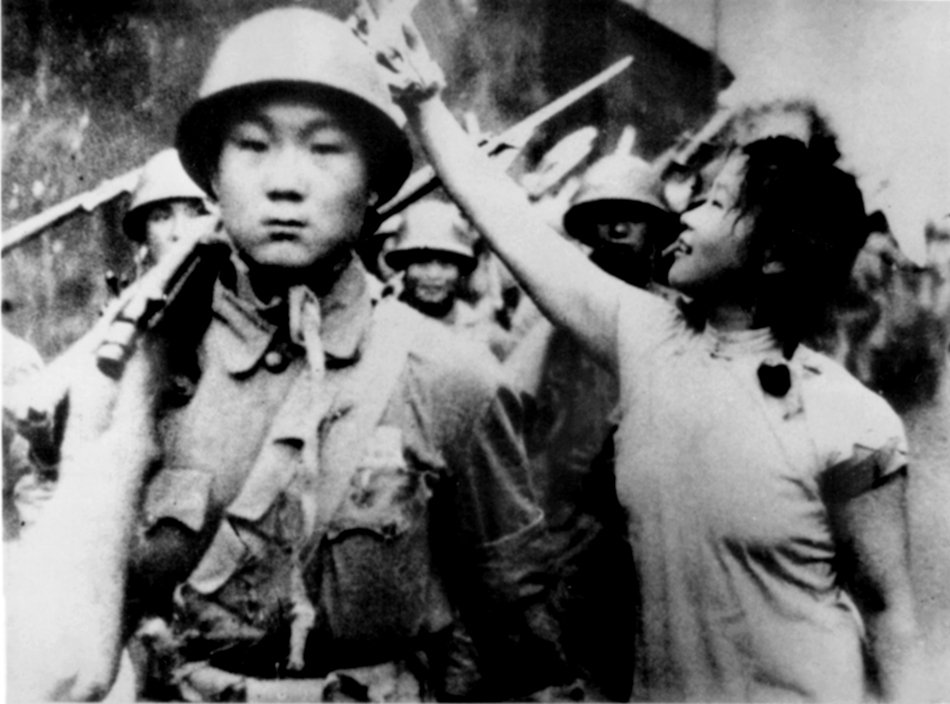 一位上海姑娘把彩花挂到了解放军的枪上。宝山区档案馆 供图