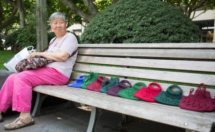 西湖旁大妈做毛线手提袋受路人追捧，两根织针编织多彩晚年