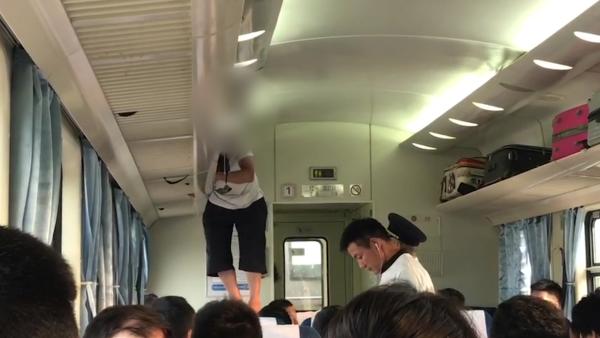 乘客两次爬火车行李架睡觉，乘务员警告
