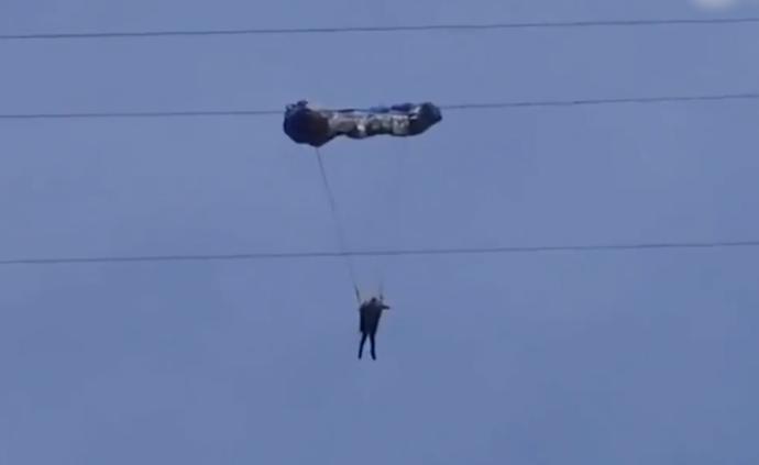 女子初学滑翔伞，挂百米高压线又被吹落