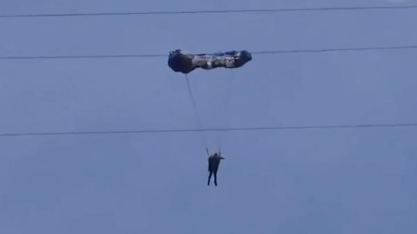 女子初学滑翔伞，挂百米高压线又被吹落