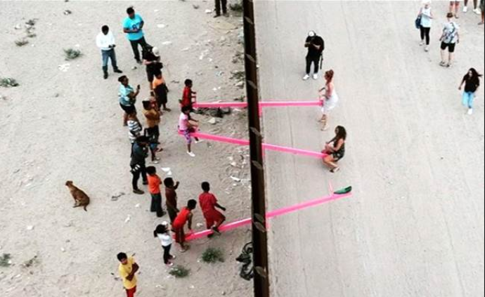 美墨边境粉色跷跷板，两国儿童隔墙玩耍