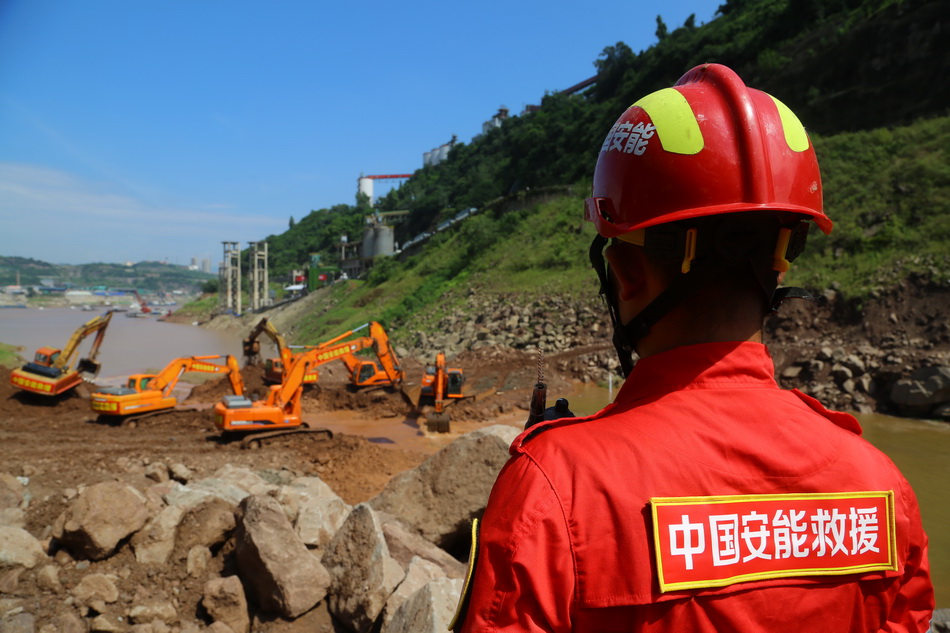 03 六台挖掘机紧张开挖泄洪槽，降低堰塞湖水位，安全员现场警戒