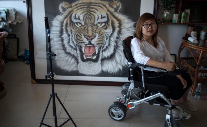 坐在轮椅上的左撇子画家，一个女人养活四口家庭