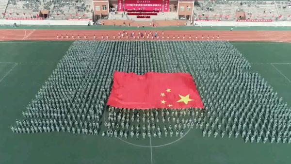 高校军训汇演，学生方阵展示巨幅国旗