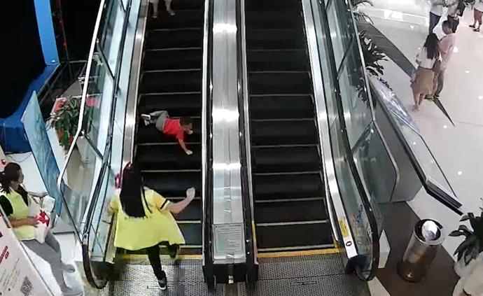 男童乘商场扶梯摔倒，女子飞奔扶起