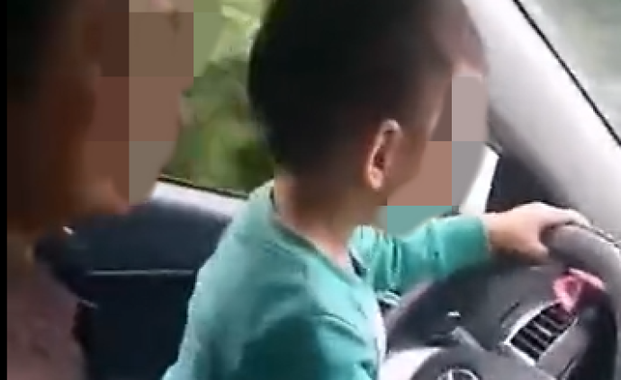 德阳一男子让小孩手握汽车方向盘操作，被记2分罚款100元