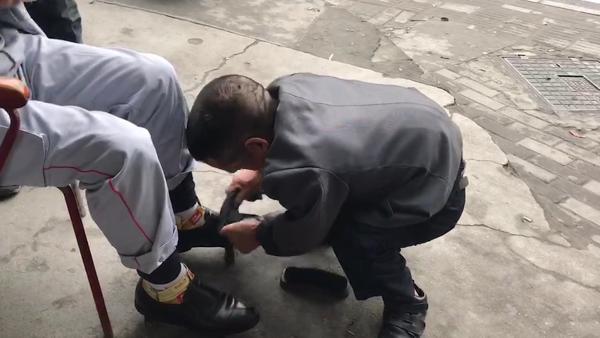 身高1米的残疾男子街头擦鞋21年