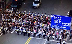手挽手站三排，上海警方在外滩人行道设“移动人墙”封锁人潮