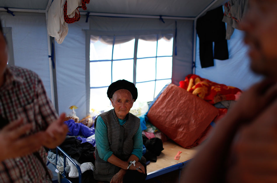 11.82岁的老奶奶张正芬坐在帐篷安置点，这次地震他失去了两个儿子和一个孙子，还有两个孙子在抢救