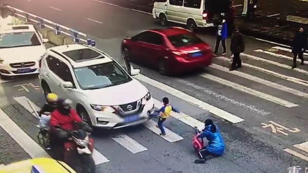 母子斑马线上被撞，男孩起身怒踹轿车