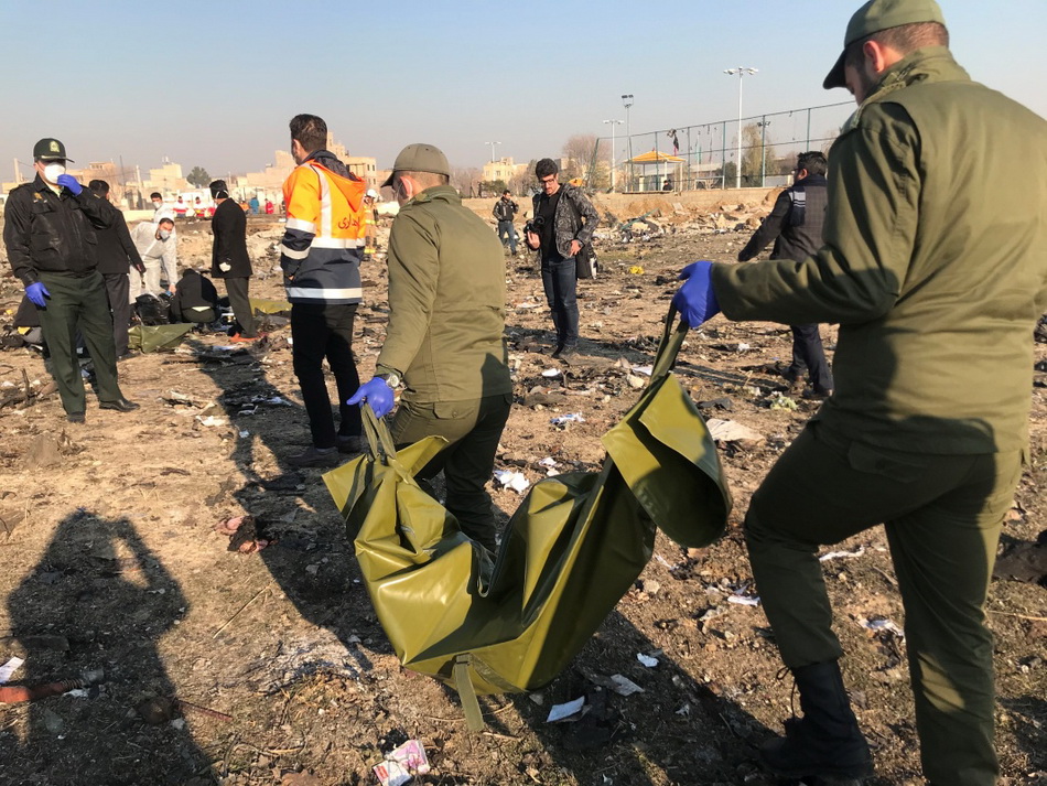 1月8日，在伊朗德黑兰郊外，救援人员在坠机现场查看飞机残骸