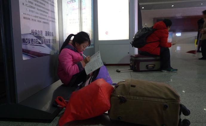 回家路丨小学生在火车站边写作业边候车