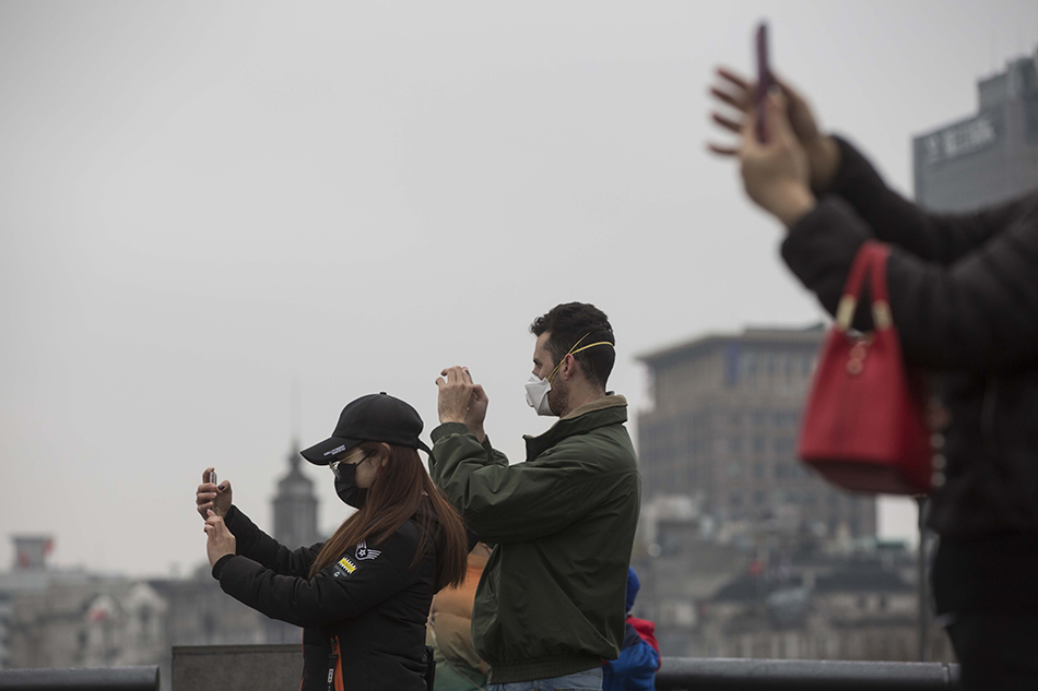 1月27日，中外游客在外滩观光平台上拍照留影。