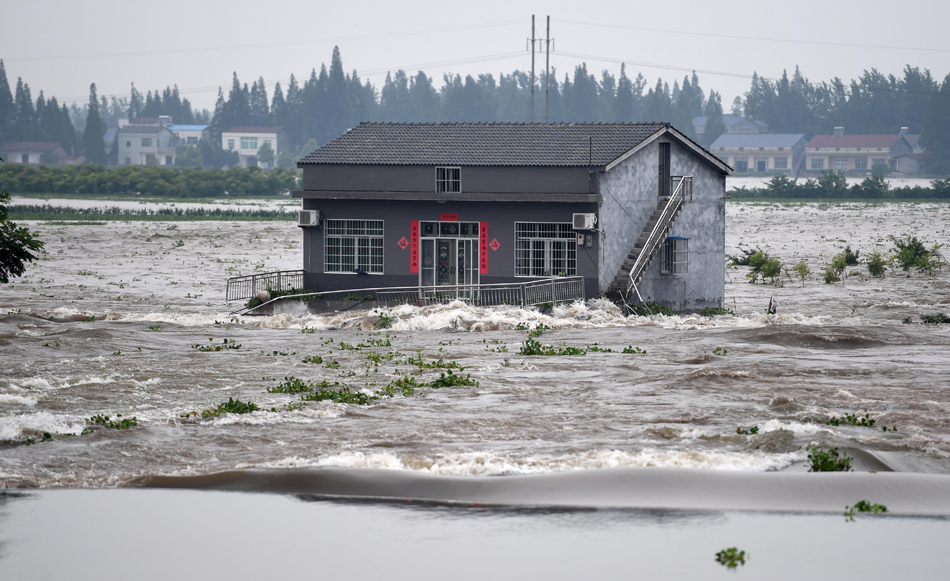12-7月10日，湖南华容县新华垸溃口现场一栋房屋被淹。