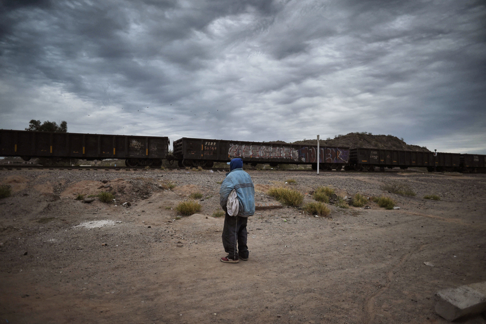 6.当地时间2017年1月13日，墨西哥索诺拉州Caborca，一名洪都拉斯移民望着火车开过。