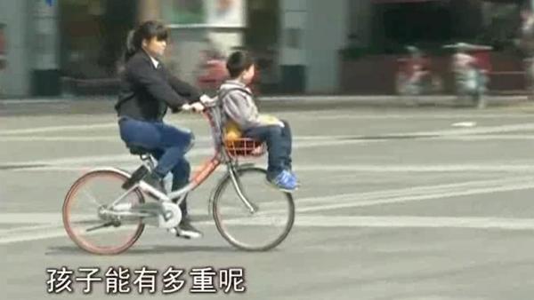 家长将共享单车车篮给孩子当“座椅”