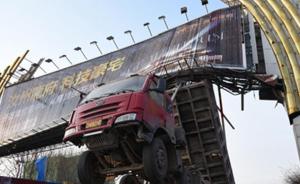 河南汝州一货车被宣传牌卡住，驾驶室悬在半空