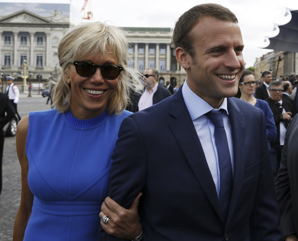 4.当地时间2015年7月14日，法国巴黎，法国经济部长埃马纽埃尔·马克龙偕妻子布丽吉特出席国庆阅兵。