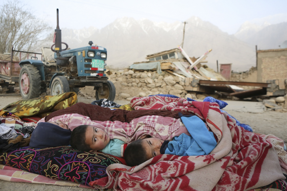 1.5月11日，两名孩子在新疆喀什地区塔什库尔干塔吉克自治县库孜滚村的临时安置点休息。