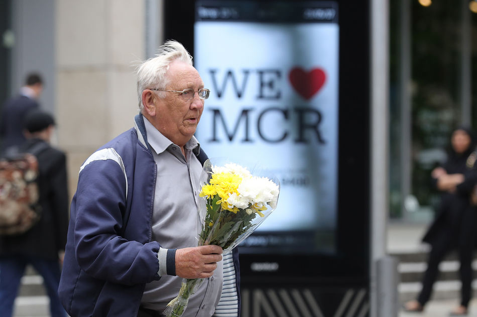2当地时间2017年5月23日，英国曼彻斯特，民众手持鲜花来到爆炸发生地附近悼念遇难者。