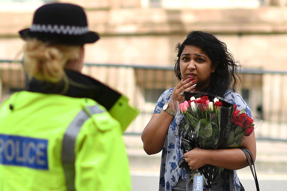 4.当地时间2017年5月23日，英国曼彻斯特，民众手持鲜花来到爆炸发生地附近悼念遇难者。4