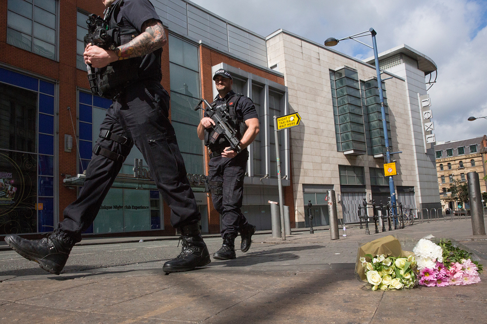 11.当地时间2017年5月23日，英国曼彻斯特，民众手持鲜花来到爆炸发生地附近悼念遇难者。3