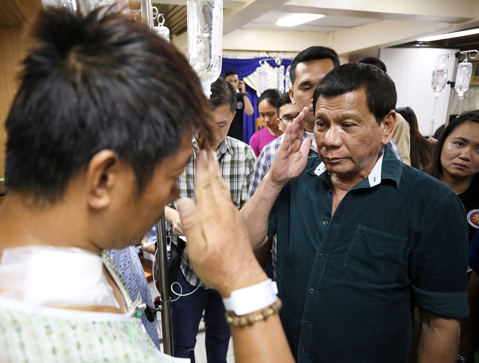 当地时间2017年5月26日，菲律宾伊利甘，菲律宾总统杜特尔特探视当地军队，图为杜特尔特向一名受伤的士兵敬礼。