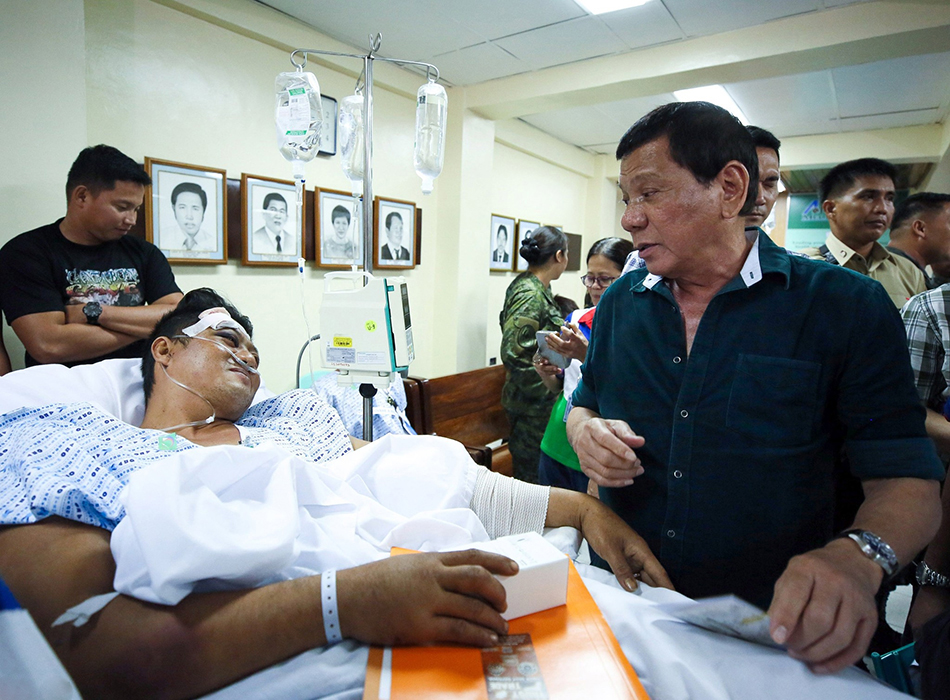 当地时间2017年5月26日，菲律宾伊利甘，菲律宾总统杜特尔特探视当地军队，图为杜特尔特与伤员交谈。