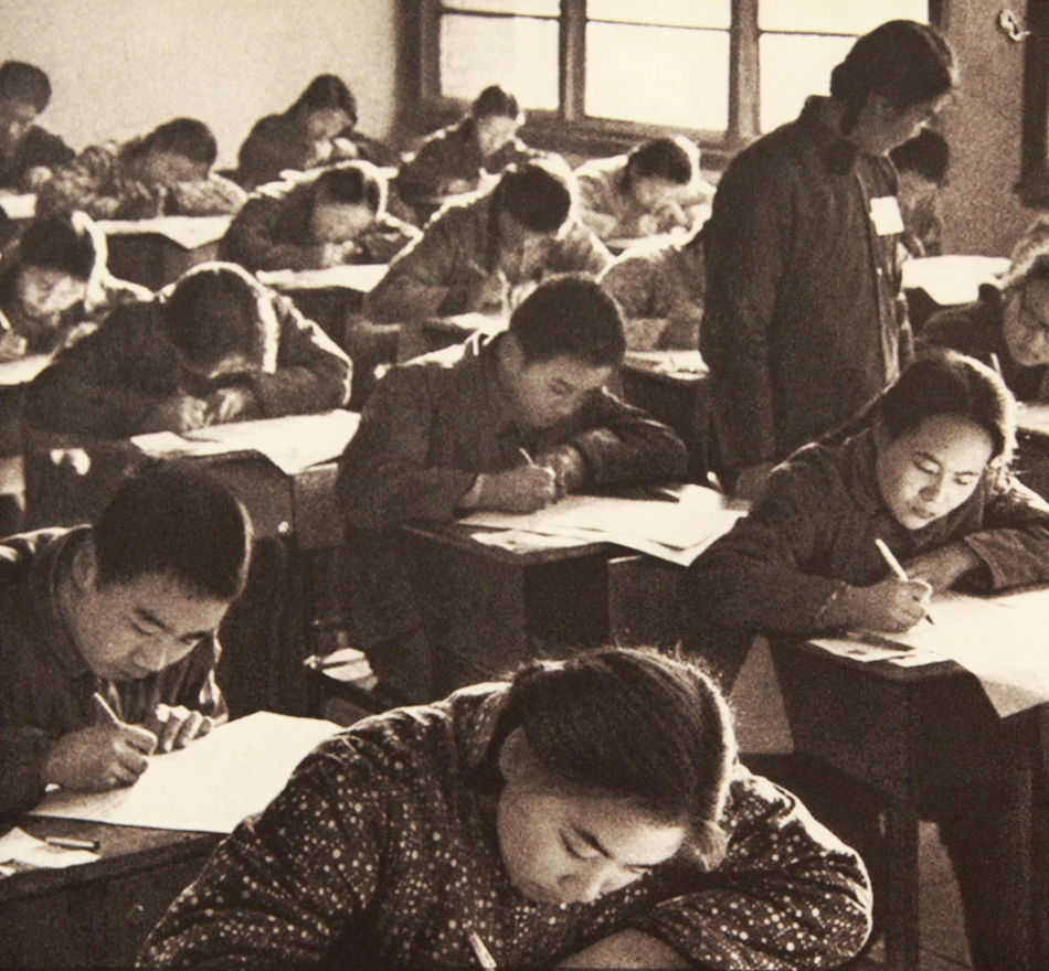 1.1977年恢复高考，在一高考的考试现场，考生们在紧张的答题，一位监考老师在巡考。