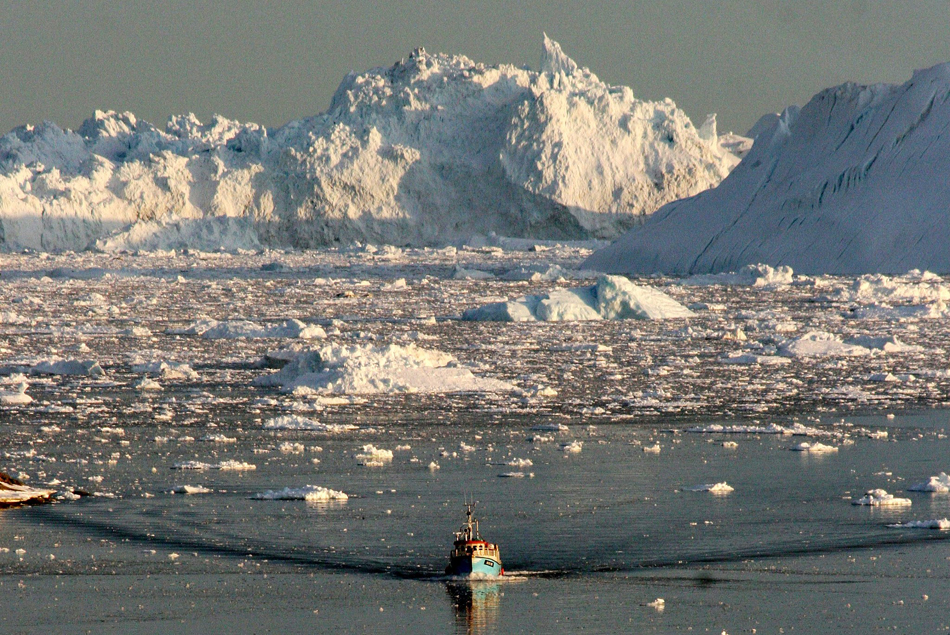 3.2014年5月13日消息，格陵兰伊卢利萨特，一艘船驶过正在融化的伊卢利萨特冰峡湾。白色的格陵兰岛伊卢利萨特冰川在全球变暖的影响下，以惊人的速度融化。