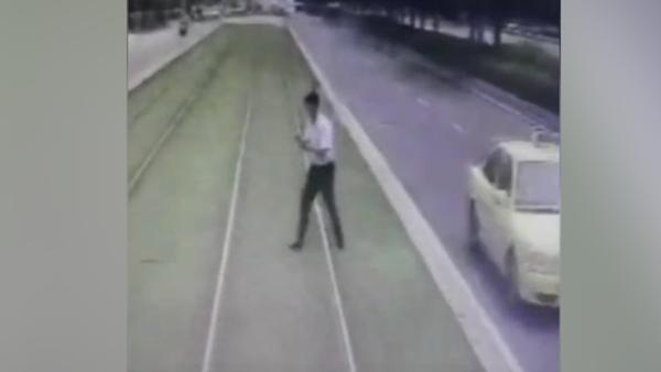 男子看手机横穿轨道，遭有轨电车撞击