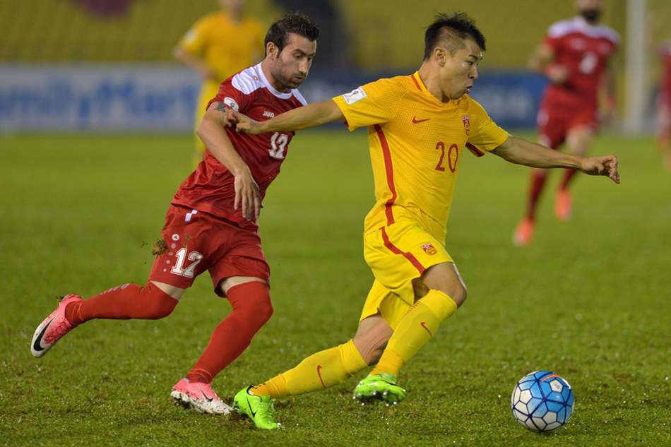 6月13日，中国队球员于汉超（右）在比赛中进攻。新华社