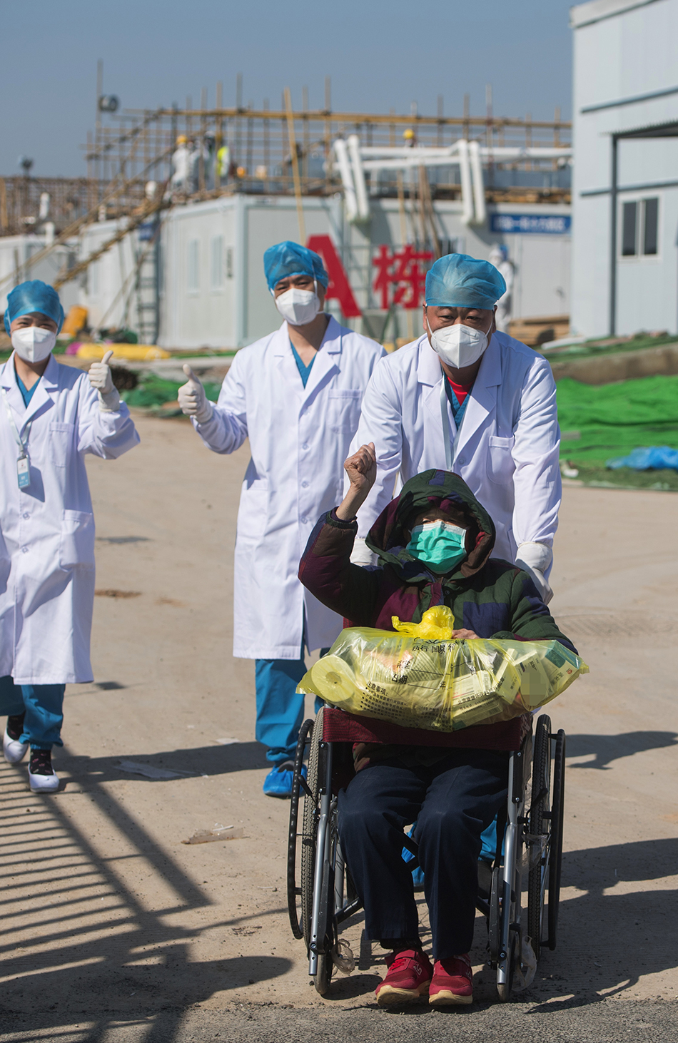 2月18日，在武汉雷神山医院，83岁的治愈患者挥手致意。