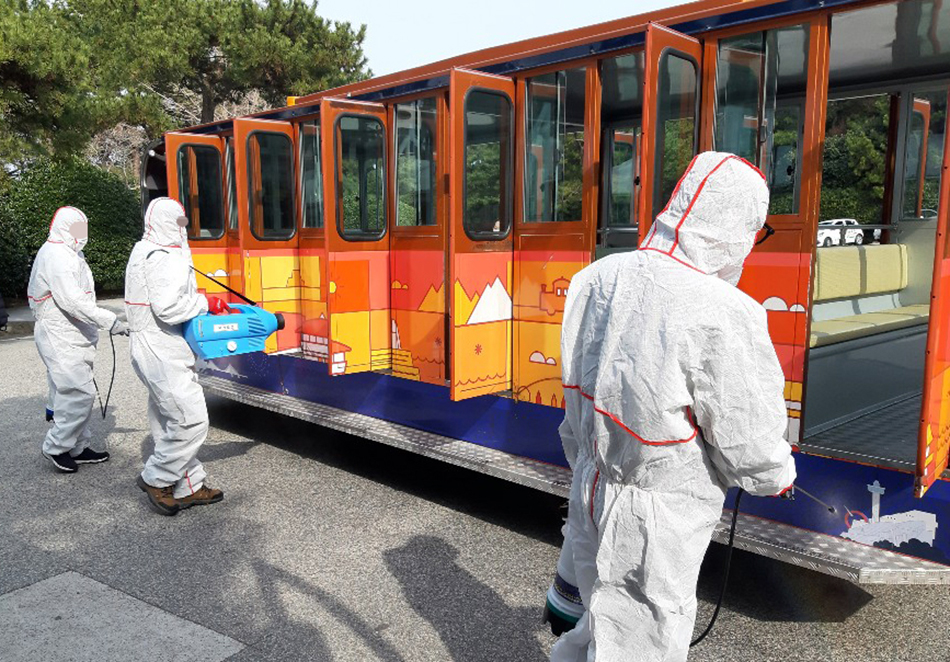 2月24日，韩国釜山市，太宗台游园地从当天起关闭，防疫人员给观光车喷洒消毒剂。