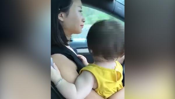 女司机一手抱女儿一手开车：女儿哭啊